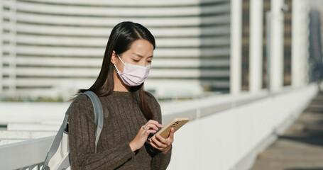 Wall Mural - Woman wear face mask and use of smart phone to check her car on parking lot