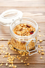 Poster - Tasty granola in glass jar on brown wooden background