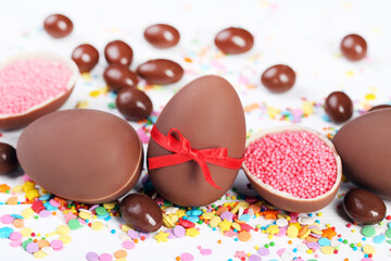 Sticker - Easter chocolate eggs with colorful sprinkles on white wooden table