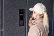 © Angelov - Close up the female hand presses the doorphone button. The girl is calling the intercom. Means of communication or notification of arrival and security of the entrance inside