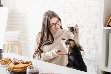 Young woman drinking hot black coffee sitting at the white table