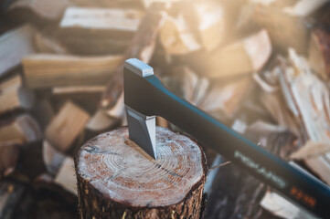 Canvas Print - Detail of axe. Axe and firewood. Sharp ax standing on a wooden, tree stump on a background of chopped wood.