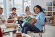 © Ivan - Young tutor is teaching to read her student. Elementary school kids sitting on desks and reading books in classroom