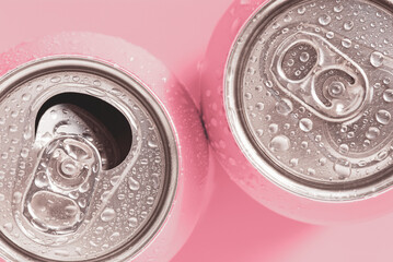 Pink soda cans in water drops, top view