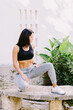 © shevtsovy - Fitness woman doing stretching legs exercise outdoors. Slim Fitness model posing. Female runner in sportswear exercising morning routine. Slim athletic woman run workout.