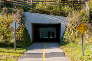 Wall Mural - Cyclists Pass Through Tunnel on a Biking Path