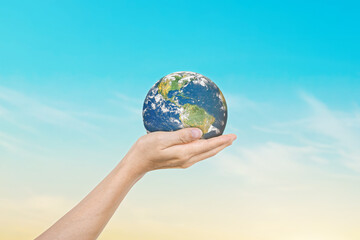 Canvas Print - globe in hands over blue sky background. save of earth. elements of this image furnished by nasa