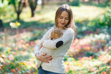 portrait a woman stroking big red fluffy cat on nature. 
friendship people and animal. smiling woman and her lovely funny pet on walk outdoors. healthy young cat with owner. Pets and lifestyle concept