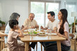 © Kawee - Asian big family enjoy eating food together, sitting on dining table.