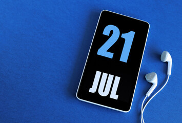 July 21. 21 st day of the month, calendar date. Smartphone and white headphones on a blue background. Place for your text. Summer month, day of the year concept