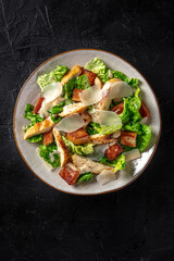 Wall Mural - Chicken Caesar salad with lettuce and cheese, shot from the top