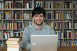 © Grustock - Male student using laptop studying in the university library