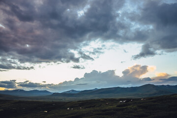 Wall Mural - beautiful mountain scenery with horses and golden dawn light in cloudy sky. scenic mountain landscap