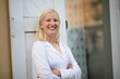 © liderina - Portrait of smiling blond woman on street.