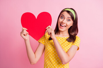 Wall Mural - Photo of young beautiful cheerful smiling lovely pretty attractive girl hold big red heart isolated on pink color background