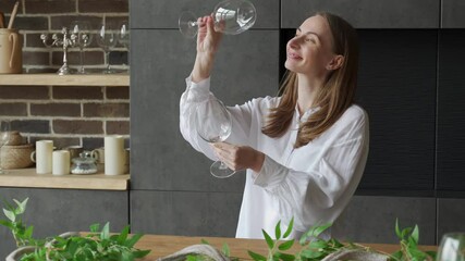 Sticker - Woman takes a glass out of the dishwasher while standing in the kitchen