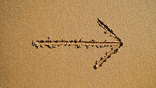 An Arrow That Marks The Direction, An Inscription On The Sand By The Ocean.