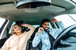 © F8  \ Suport Ukraine - Happy cheerful indian couple having fun while sitting in a car