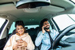 © F8  \ Suport Ukraine - Young indian couple on the red car, man using moblie phones while drive car.