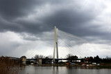 Fototapeta Mosty linowy / wiszący - Piękny linowy most drogowy nad rzeką w burzową pogodę. 