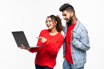 Wall Mural - Attractive young indian couple holding their laptop on white background