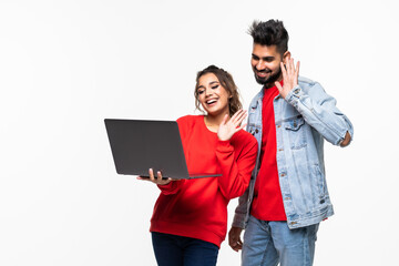 Wall Mural - Young indian couple with laptop make video call on white background