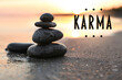 Karma concept. Stones on sand near sea at sunset