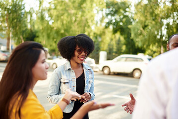 Happy multiethnic young people relax together have fun talking and chatting sharing ideas. friendship, leisure, summer and people concept