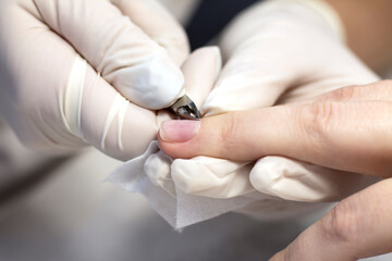 Manicure hand nail care with a special device in a beauty salon by a manicure specialist. Close-up. Space for the text.