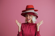 Funny Woman Wearing Many Hats  Posing On Pink Background. Model Looking Aside. Fashion, Sale, Shopping Advertising Conception. Copy, Empty Space For Text