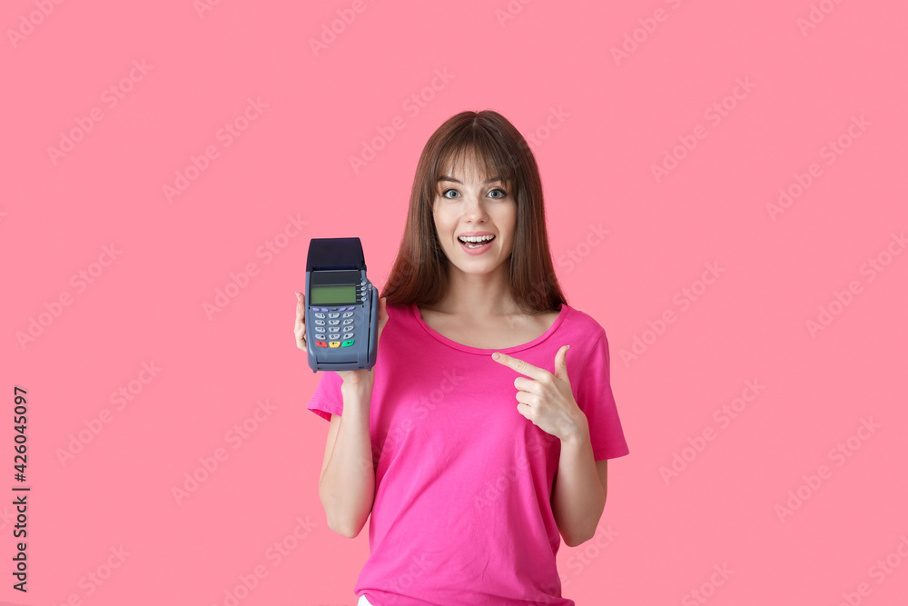 Young woman with payment terminal on color background
