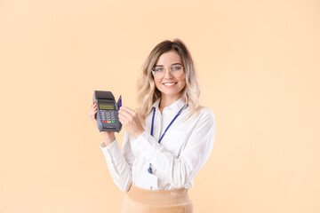 Wall Mural - Young woman with payment terminal on color background