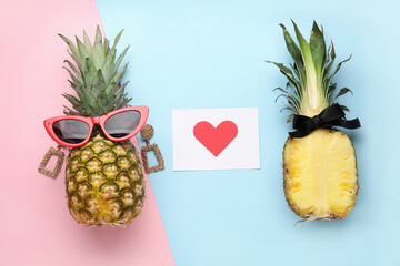 Pineapples with female accessories and paper with heart on color background