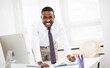 © chagin - Happy african american businessman smiling at camera in office