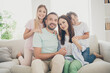 © deagreez - Photo of optimistic cute full family with two kids hug sit on sofa wear t-shirts trousers at home