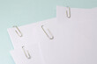 metal paper clips attached to a blank white paper