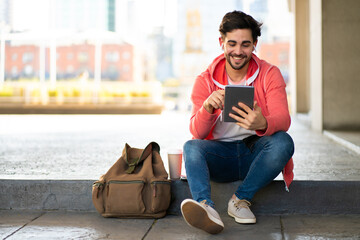 Young man using digital tablet outdoors.