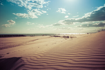 South of France beach at sunset with cloudy sky in the background, and sand dunes in the foreground, shot near Agde, Herault, France