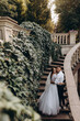 Walk of the newlyweds near the stone mansion. Warm summer evening. Portrait of the bride and groom. Evening photo session.