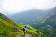 © Miguel - Young man taking pictures of a huge valley in mini Adams Peak, Sri Lanka.