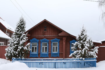 Vintage wooden rural house in Dunilovo village in Ivanovo region, Russia. Building facade; ornamental windows with carved frames. Russian traditional national folk style in architecture. Countryside