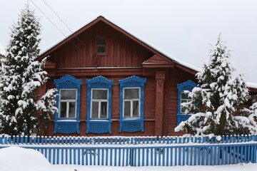 Vintage wooden rural house in Dunilovo village in Ivanovo region, Russia. Building facade; ornamental windows with carved frames. Russian traditional national folk style in architecture. Countryside