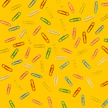 Multi Colored Paper Clips Scattered Against Yellow Background