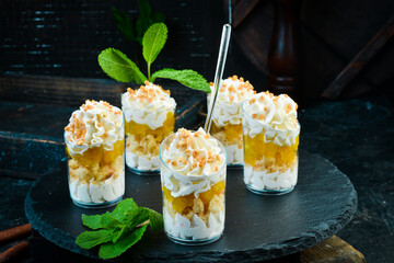 Lemon creamy mini dessert in a glass. Candy bar. On a black stone background, top view.