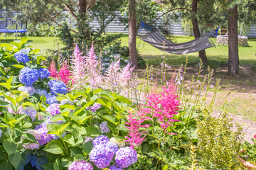 Wall Mural - Garden yard design. Beautiful landscape with garden corner. Blooming flowers background