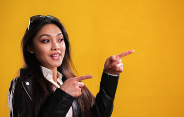 Wall Mural - Young happy woman points to something - studio photography