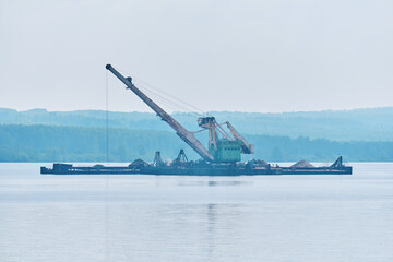 dredging boat is working to deepen the fairway on the river