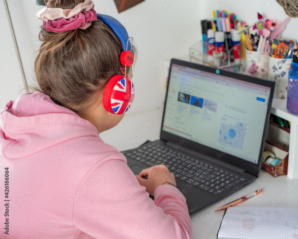 Dziecko uczy się przy biurku w swoim pokoju , lekcje online , nauczanie zdalne podczas pandemii koronawirusa - obrazy, fototapety, plakaty 