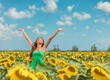 © Maridav - Happy free Asian woman dancing with arms up of hapiness in sunflowers field celebrating spring relaxing in the sun. Girl enjoying nature looking up sunbathing in fresh air.
