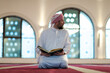 © .shock - muslim man praying Allah alone inside the mosque and reading islamic holly book